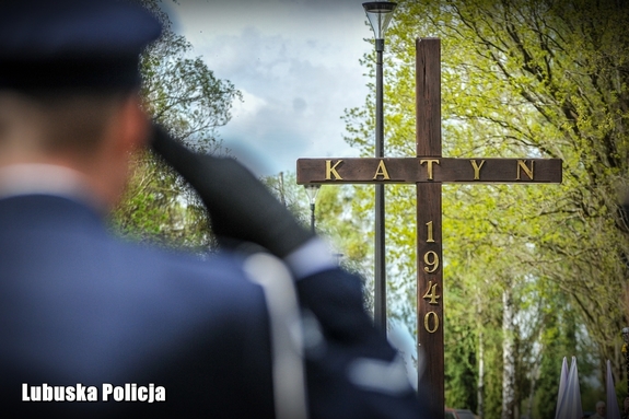 policjant oddaje honor do Krzyża Katyńskiego
